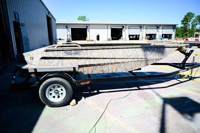 Slide: The Image of 2023 Edge Duck Boats 17 on trailer, parked outside industrial building. - 2