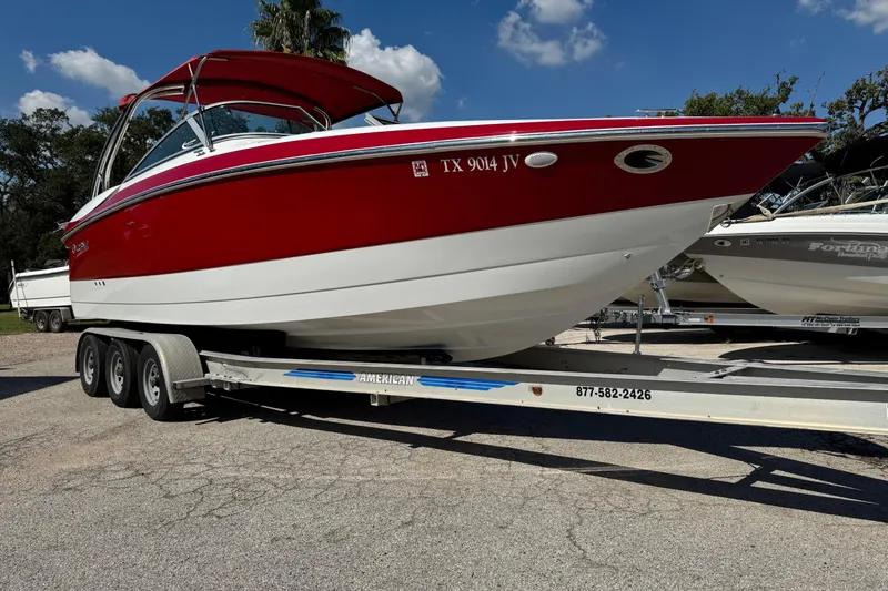 Slide: The Image of Red and white 2003 Cobalt 282 boat on a trailer under a clear blue sky. - 0