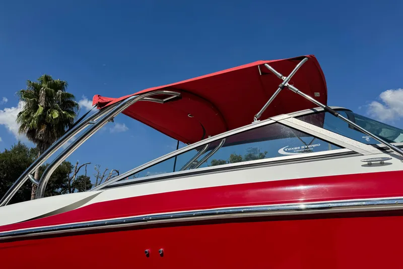 Slide: The Image of Red 2003 Cobalt 282 boat with canopy against blue sky and palm tree background. - 3