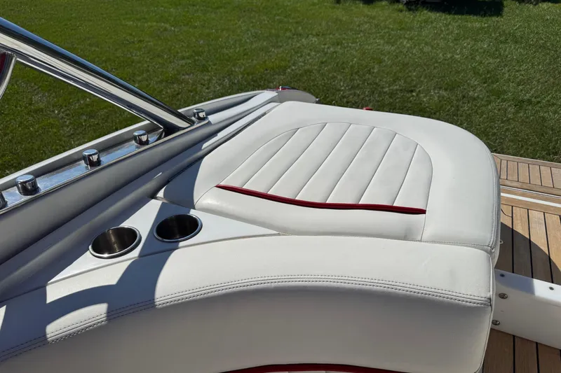 Slide: The Image of Luxurious white seating on 2003 Cobalt 282 boat with cup holders, set against green grass. - 37