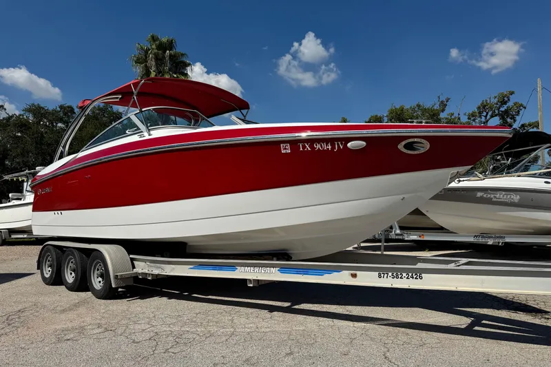 Slide: The Image of Red and white 2003 Cobalt 282 boat on trailer under clear blue sky. - 42