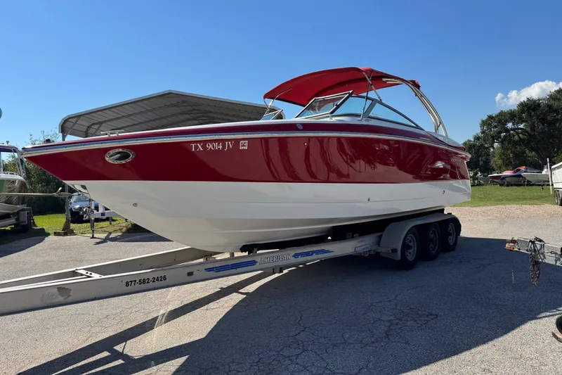 Slide: The Image of 2003 Cobalt 282 boat with red and white exterior on a trailer in a sunny outdoor setting. - 43