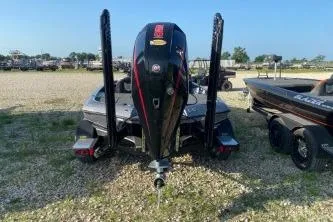 Slide: The Image of 2023 Blazer 650 Pro Tour boat, rear view, parked on gravel. - 4