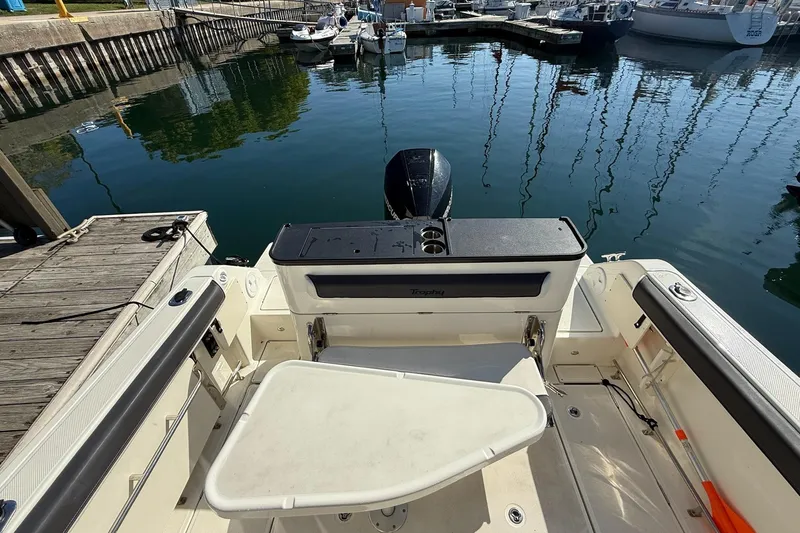 Slide: The Image of 2024 Bayliner Trophy T25 Pilothouse boat docked, showcasing spacious deck and seating area. - 18