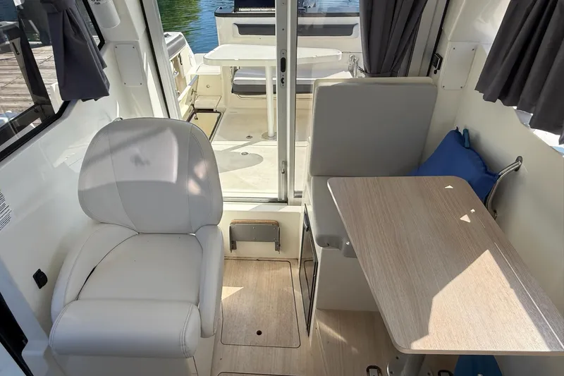 Slide: The Image of 2024 Bayliner Trophy T25 Pilothouse interior with seating and table, featuring modern design. - 40