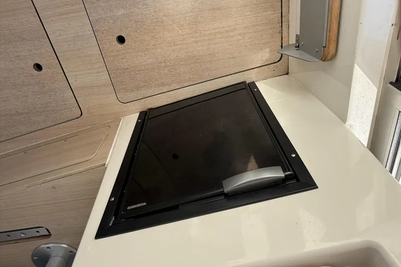 Slide: The Image of 2024 Bayliner Trophy T25 Pilothouse interior with closed hatch and wooden paneling. - 43