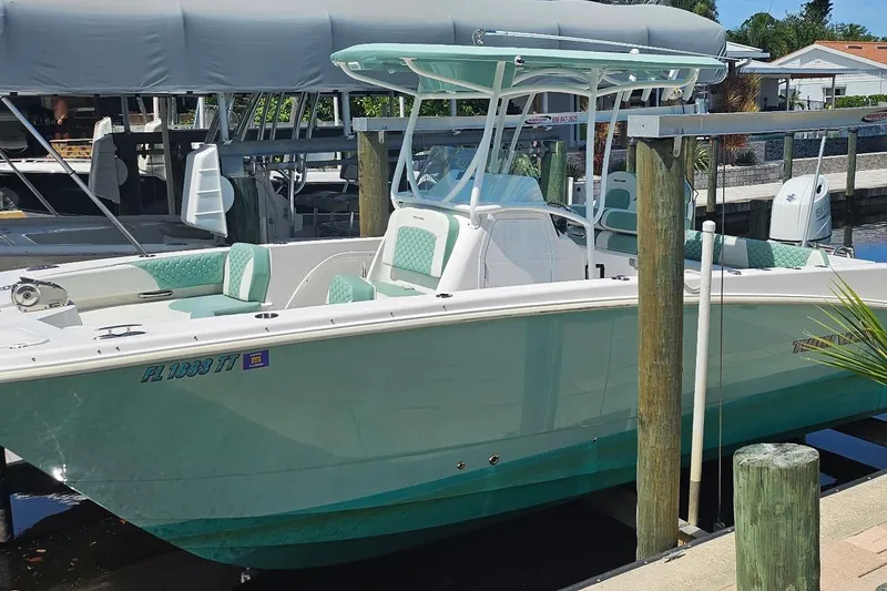 Slide: The Image of 2024 Twin Vee 240 GFX CC boat docked, featuring mint green accents and modern design. - 2
