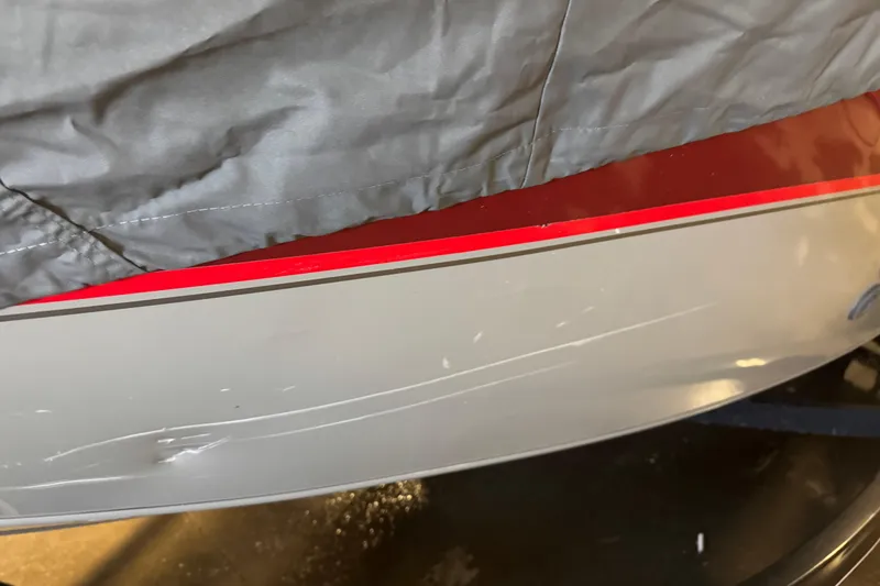 Slide: The Image of 2014 Tracker Pro Guide V-175 Combo boat with visible scratches and protective cover. - 16