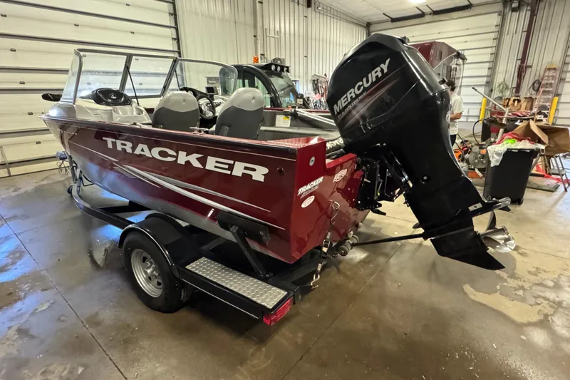 Slide: The Image of 2014 Tracker Pro Guide V-175 Combo boat with Mercury engine in a garage setting. - 4