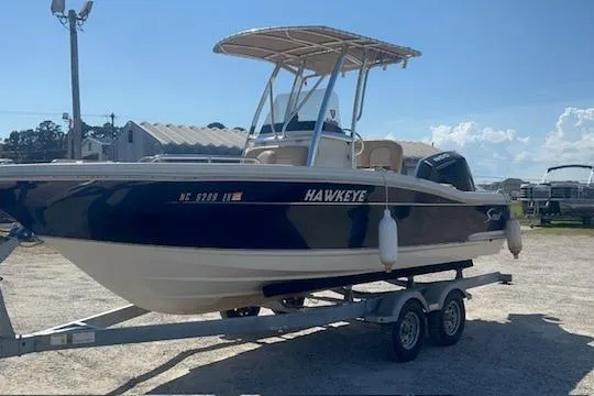 The Image of 2022 Scout 215 XSF boat named "Hawkeye" on a trailer in a sunny outdoor setting. - 1