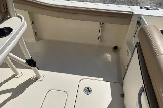 Slide: The Image of 2022 Scout 215 XSF boat interior with beige seating and storage compartments. - 11