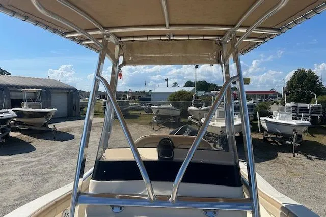 Slide: The Image of 2022 Scout 215 XSF boat with T-top in a sunny outdoor showroom. - 17