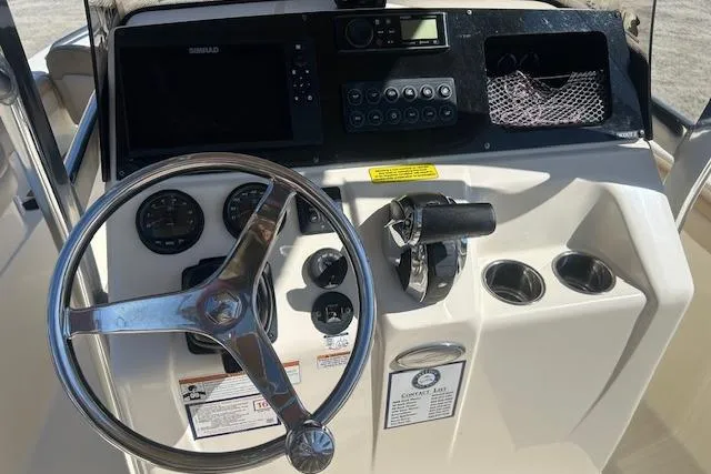 Slide: The Image of 2022 Scout 215 XSF boat dashboard with steering wheel, controls, and navigation system. - 23