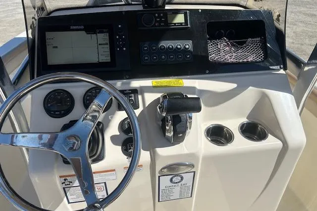 Slide: The Image of 2022 Scout 215 XSF boat dashboard with steering wheel, controls, and navigation system. - 25