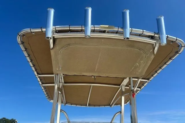 Slide: The Image of 2022 Scout 215 XSF boat canopy with rod holders against clear blue sky. - 27