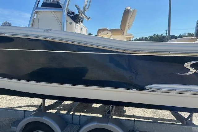 Slide: The Image of 2022 Scout 215 XSF boat on trailer, side view with sleek design. - 7