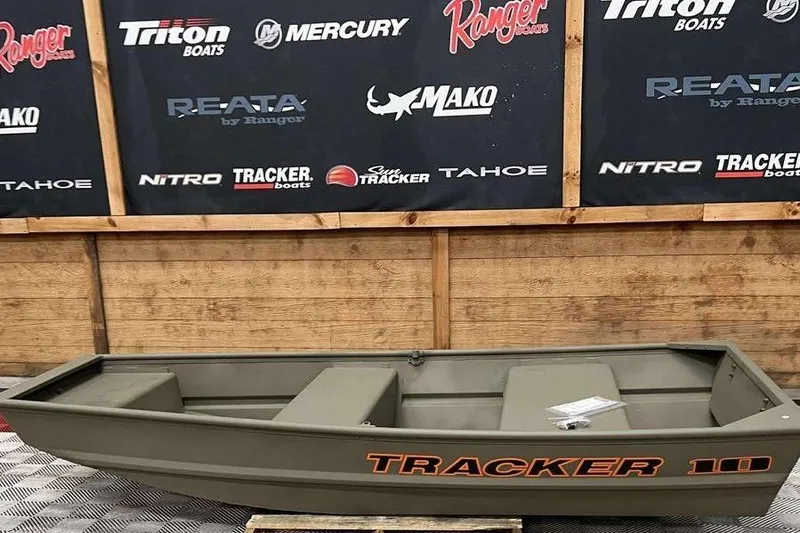 The Image of 2026 Tracker Grizzly 1036 Utility boat displayed indoors with branded backdrop. - 1