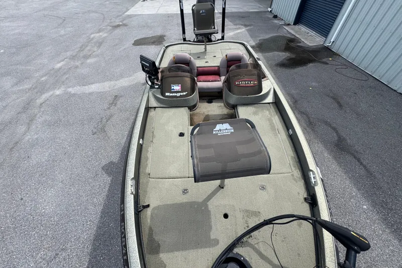 Slide: The Image of 2000 Ranger 520DVX Comanche fishing boat with seating and equipment on a concrete surface. - 10