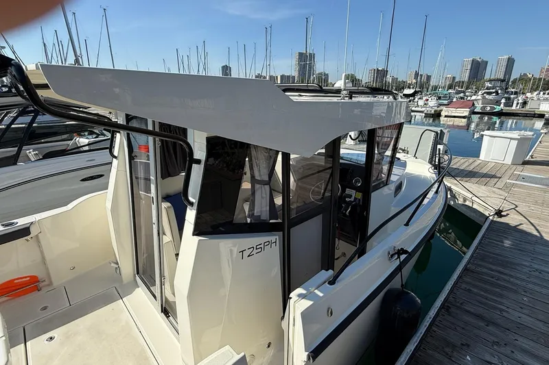 Slide: The Image of 2024 Bayliner Trophy T25 Pilothouse docked at marina, showcasing sleek design and modern features. - 12
