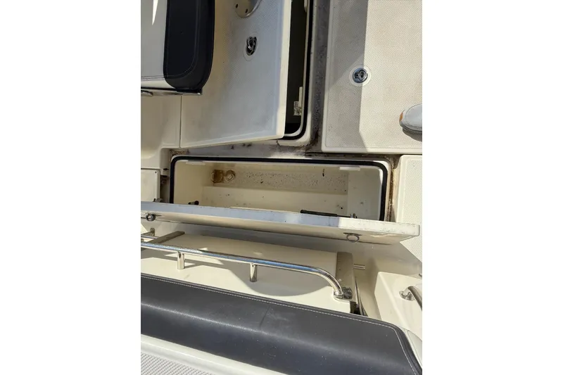 Slide: The Image of 2024 Bayliner Trophy T25 Pilothouse storage compartment, open and empty, with visible seating area. - 29