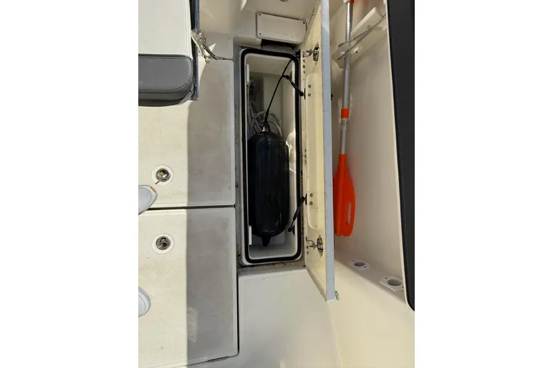 Slide: The Image of 2024 Bayliner Trophy T25 Pilothouse storage compartment with paddle and equipment. - 31