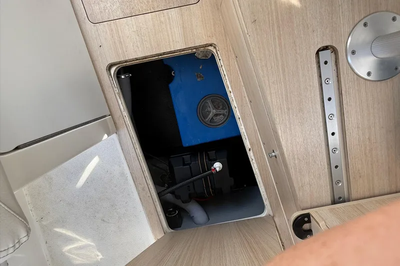 Slide: The Image of 2024 Bayliner Trophy T25 Pilothouse interior compartment with blue equipment and wooden finish. - 47