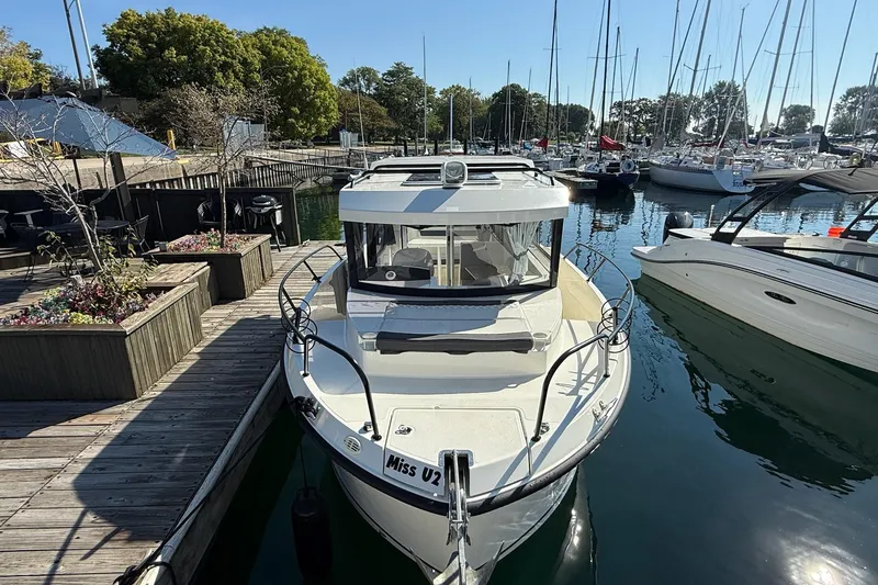 Slide: The Image of 2024 Bayliner Trophy T25 Pilothouse docked at marina, surrounded by sailboats. - 7