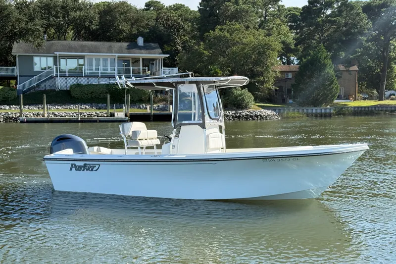 The Image of 2020 Parker 2100 Special Edition boat on calm water near a lakeside house. - 0