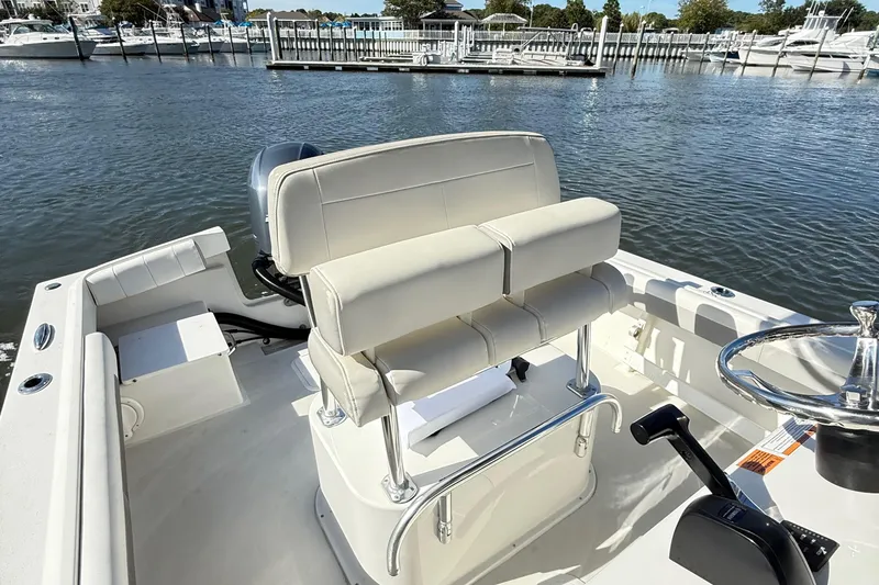Slide: The Image of 2020 Parker 2100 Special Edition boat interior with helm and seating, docked by marina. - 14