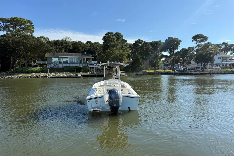 Slide: The Image of 2020 Parker 2100 Special Edition boat on calm water near waterfront homes. - 2
