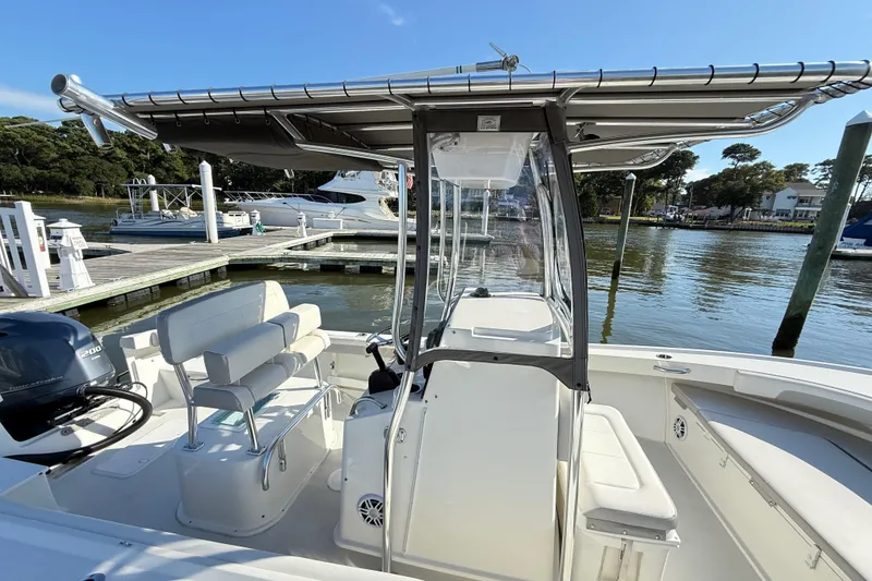 Slide: The Image of 2020 Parker 2100 Special Edition boat docked at marina, featuring spacious seating and canopy. - 23