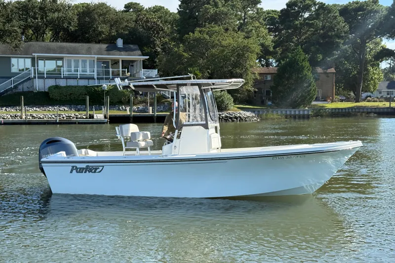 Slide: The Image of 2020 Parker 2100 Special Edition boat on calm water near a house and trees. - 3