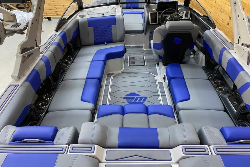 Slide: The Image of 2024 Malibu Wakesetter 23 MXZ interior with blue and gray seating, modern design. - 4
