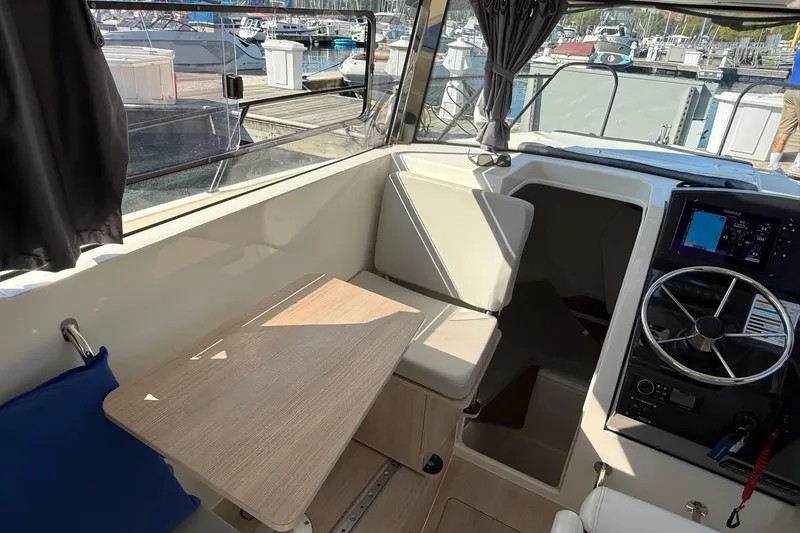 Slide: The Image of 2024 Bayliner Trophy T25 Pilothouse interior with seating, table, and steering wheel. - 38