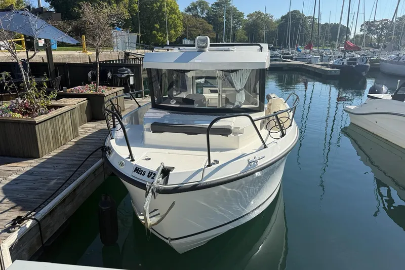 Slide: The Image of 2024 Bayliner Trophy T25 Pilothouse docked in a marina, surrounded by other boats. - 4