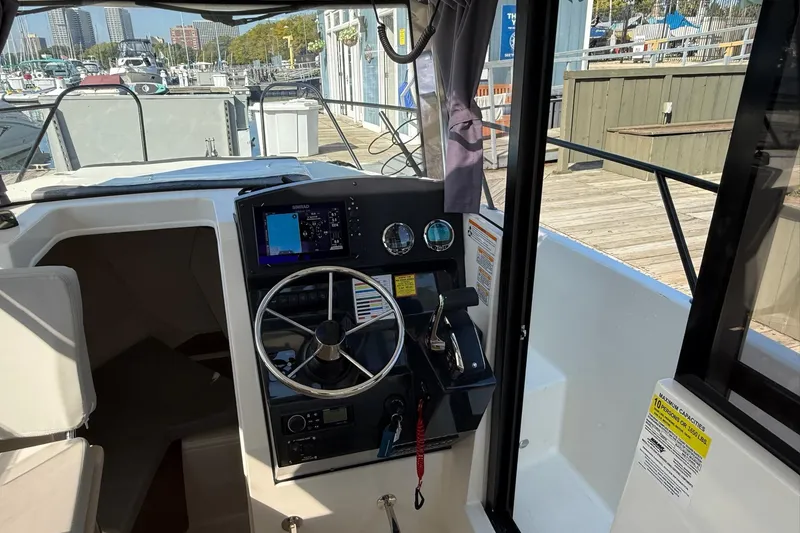 Slide: The Image of 2024 Bayliner Trophy T25 Pilothouse helm with steering wheel and navigation controls. - 42