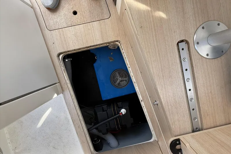 Slide: The Image of 2024 Bayliner Trophy T25 Pilothouse interior compartment with blue equipment and wooden flooring. - 48