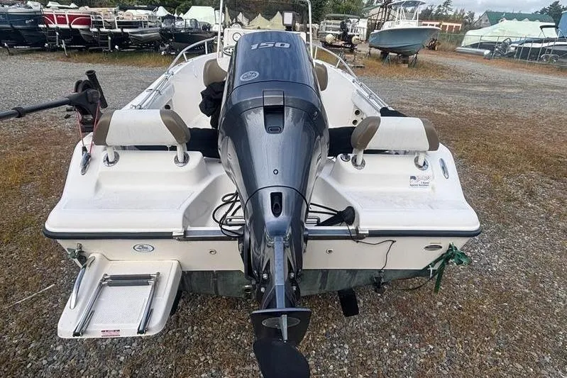 Slide: The Image of 2013 Key West 186 Center Console boat with outboard motor, parked on gravel. - 2
