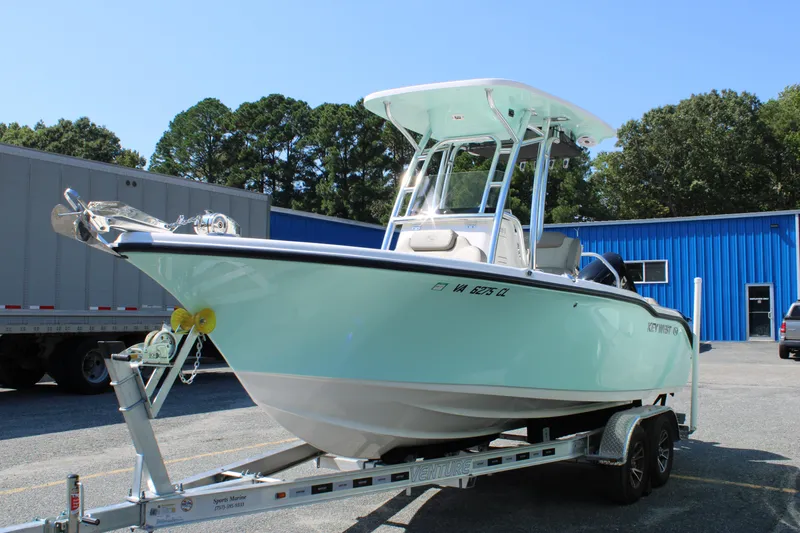 Slide: The Image of 2024 Key West 219 FS boat on trailer, parked outside blue building. - 3