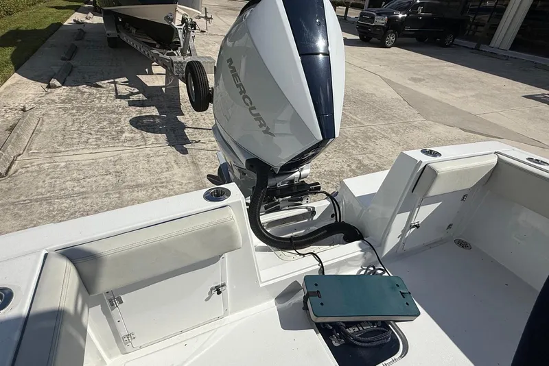 Slide: The Image of 2001 Contender 21 Open boat with Mercury outboard engine, parked on a concrete surface. - 4