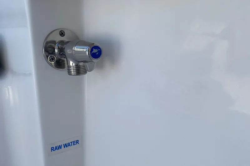 Slide: The Image of 2024 Tidewater 180 CC Adventure raw water outlet detail, featuring a chrome faucet. - 13