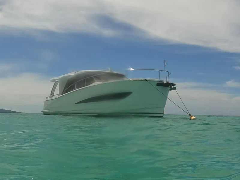 Slide: The Image of 2022 Greenline 39 Hybrid yacht anchored in clear turquoise water under a blue sky. - 42