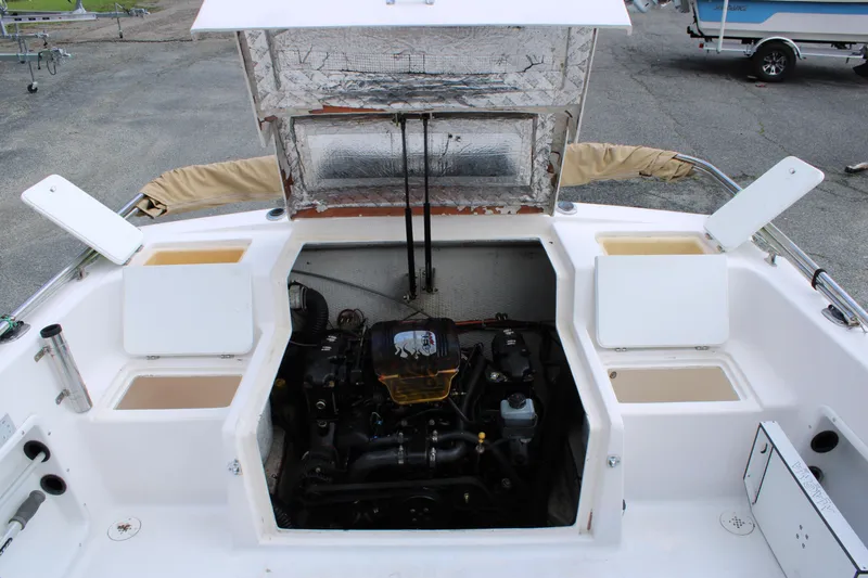 Slide: The Image of 2005 Angler 220 WA boat engine compartment with open hatches and visible engine components. - 10