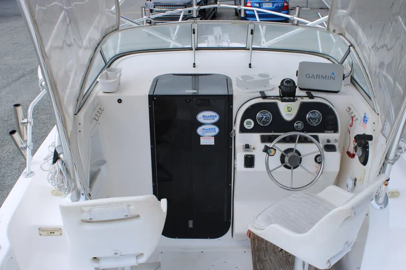 Slide: The Image of 2005 Angler 220 WA boat cockpit with steering wheel and Garmin navigation system. - 13