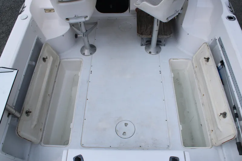Slide: The Image of 2005 Angler 220 WA boat interior with open storage compartments and seating. - 14