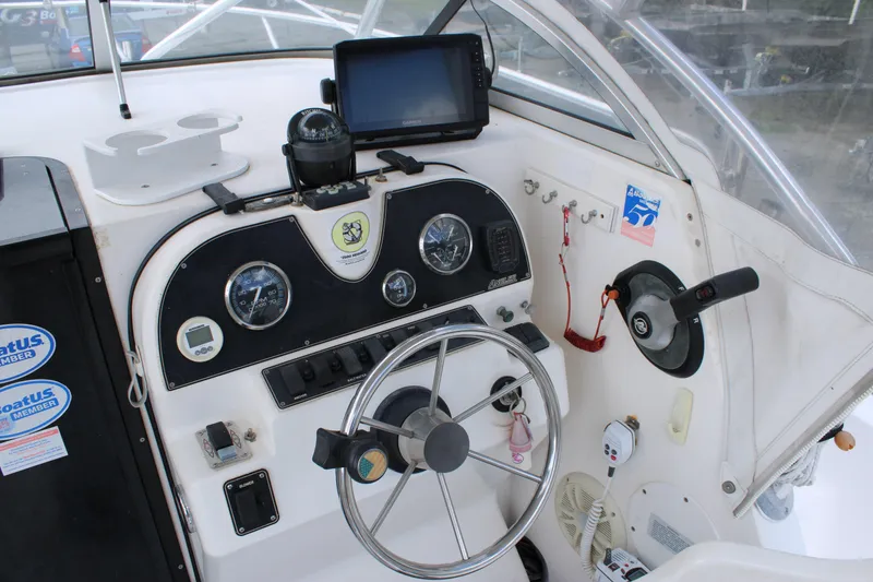 Slide: The Image of 2005 Angler 220 WA boat dashboard with steering wheel, gauges, and navigation equipment. - 15