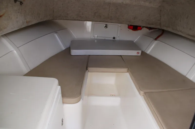 Slide: The Image of 2005 Angler 220 WA cabin interior with beige cushions and storage compartments. - 19