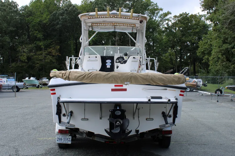 Slide: The Image of 2005 Angler 220 WA boat, rear view, parked on trailer, surrounded by trees. - 4