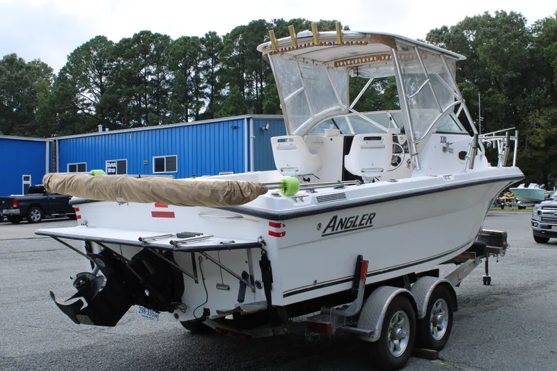Slide: The Image of 2005 Angler 220 WA boat on trailer, parked near blue building. - 5