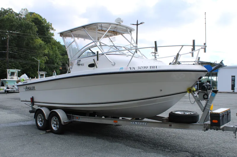 Slide: The Image of 2005 Angler 220 WA boat on trailer in parking lot, side view. - 7